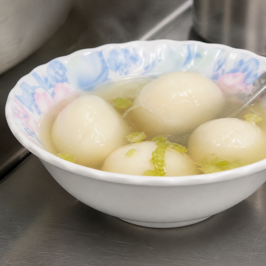 輕食組合中的魚丸湯：花邊瓷碗裡的清湯與手工大魚丸、芹菜末